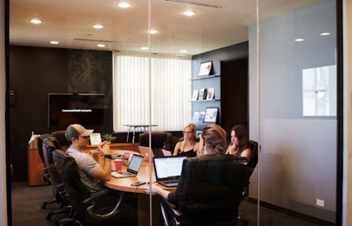 Team members gathered around a table in an office conference room, discussing how personalization impacts the target account selling methodology